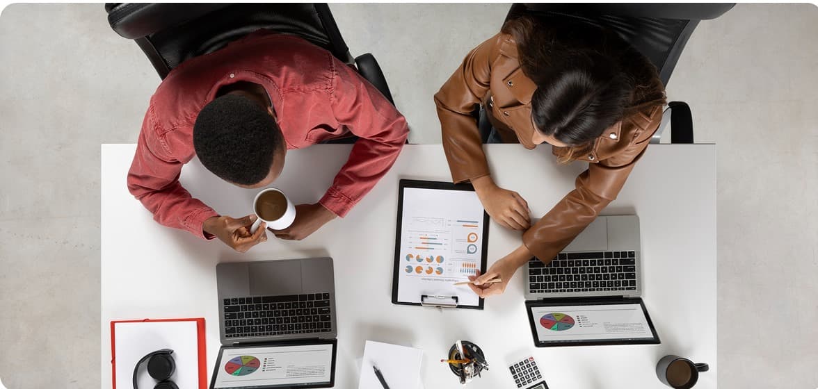 Two colleagues reviewing charts during a planning session